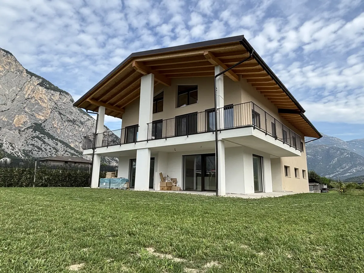 Casa nuova a due piani con tetto in legno e montagne sullo sfondo