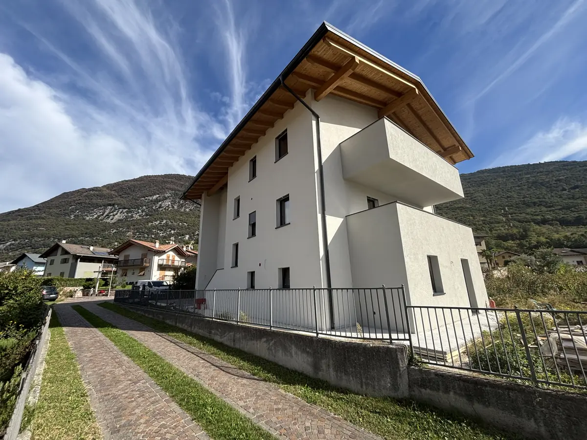 Palazzina ristrutturata con nuovo intonaco bianco e tetto in legno