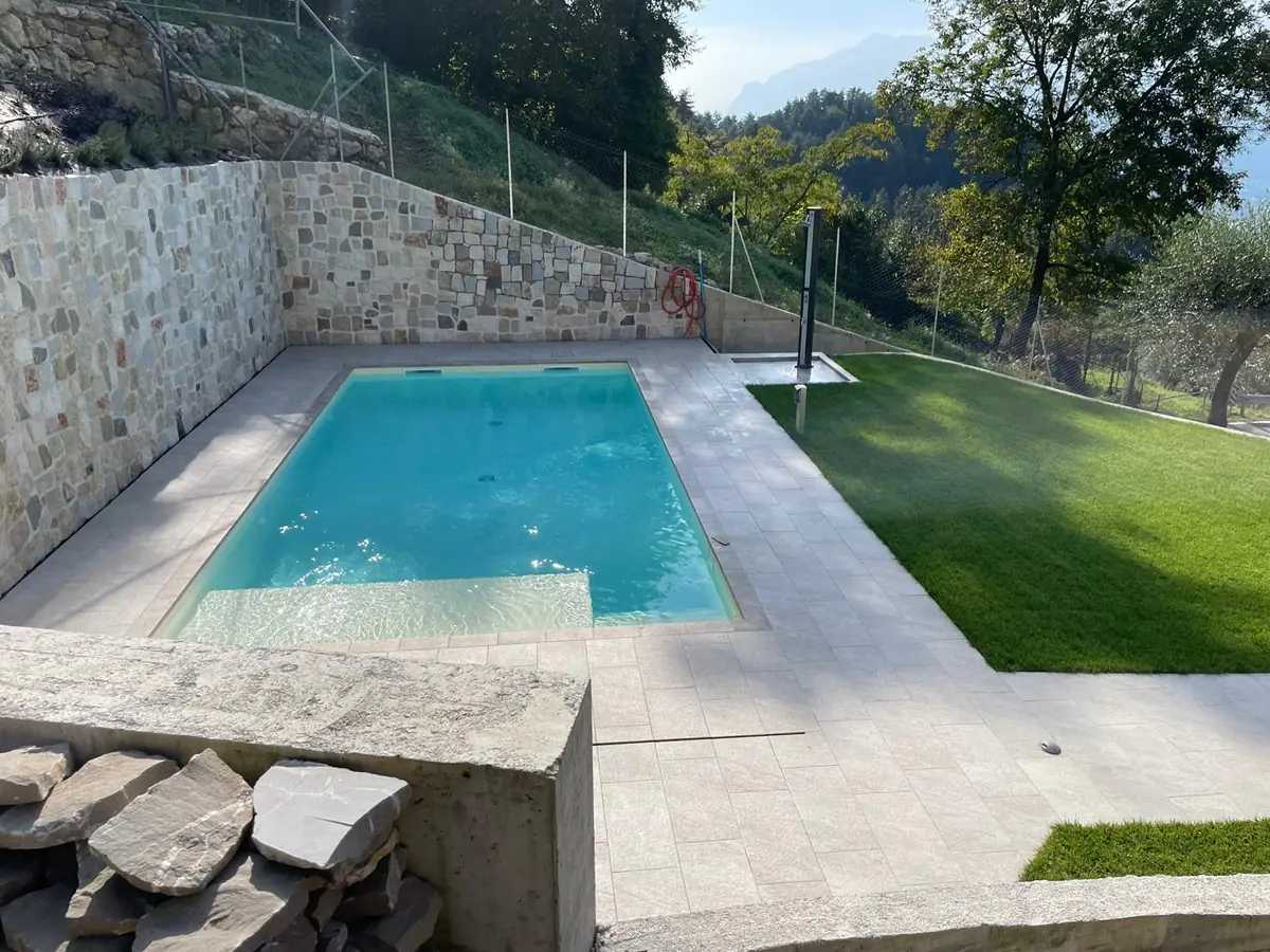 Piscina e muri in pietra realizzati in giardino