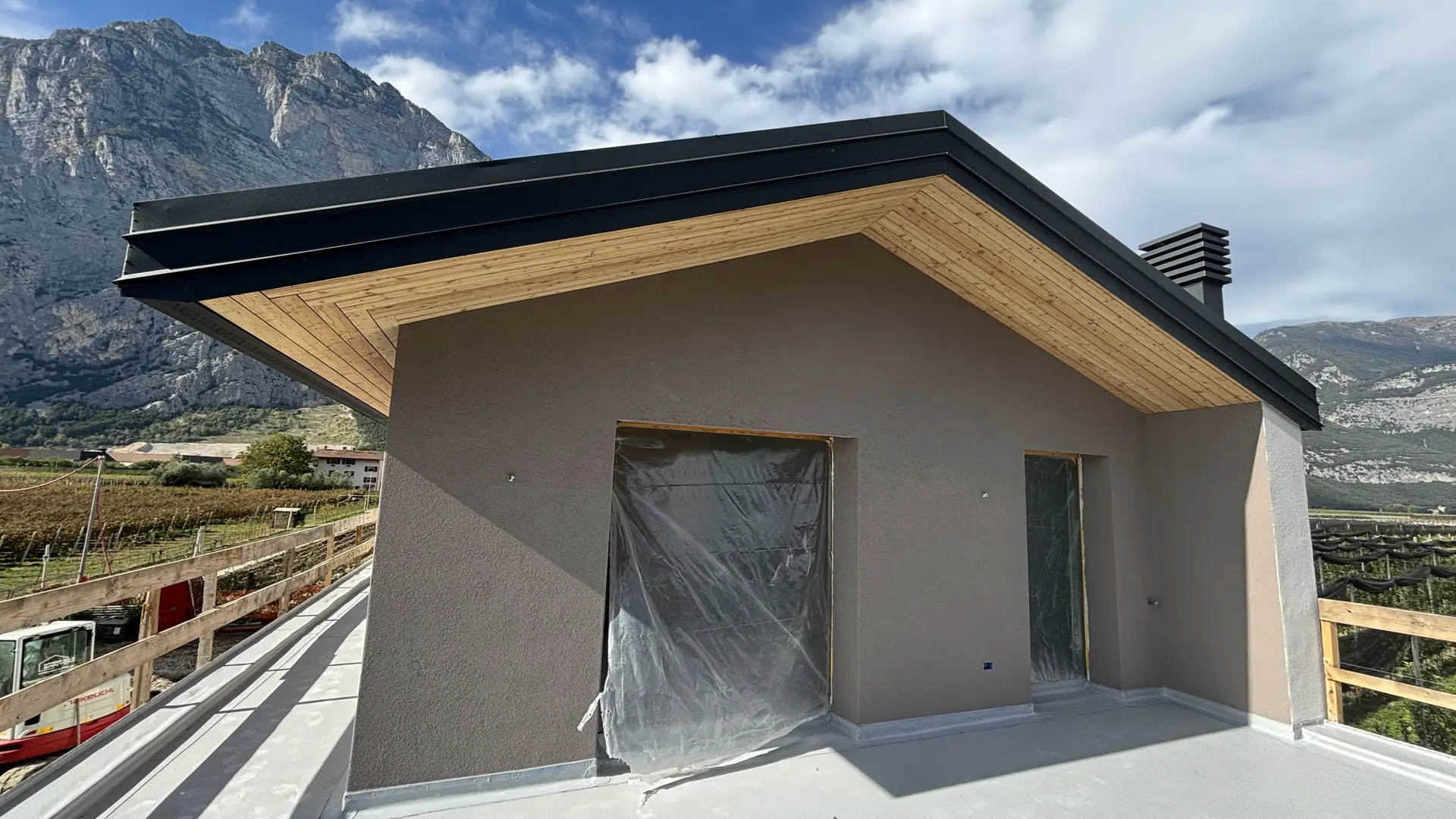 Casa con nuova copertura e gronda in larice davanti alle montagne